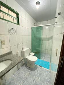 a bathroom with a toilet and a glass shower at Pousada Nenzinha in Sao Jorge