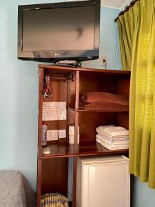 a tv sitting on top of a book shelf at Pousada Nenzinha in Sao Jorge