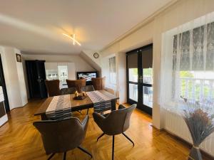 a dining room and living room with a table and chairs at Heviz Apart Comfort in Hévíz