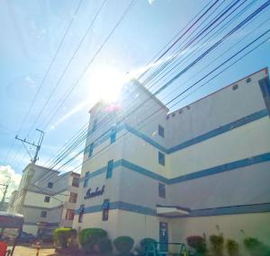 a building with the sun shining on top of it at Mamby Gray's Place Balcony, Karaoke ,Wifi,Netflix &Kitchen in Imus