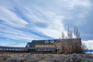 a house on the beach with a cloudy sky at Hotel Las Dunas in El Calafate