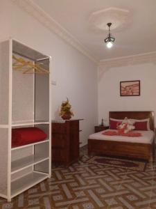 a bedroom with a bed and a book shelf at Riad Larache in Larache