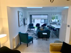 sala de estar con sofá, sillas y mesa en 3 Cosy Homes Walking Distance to Mall with Parking Available to Book Separately 3 Bed House Or 1 Bed Apartment Or Studio en Golders Green