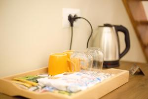 einen Tisch mit einem Tablett mit Gläsern und einer Kaffeemaschine in der Unterkunft Duplex Rooms in Korçë