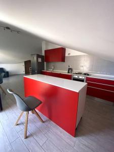 cocina con encimera roja y silla en CASA CARAGOL ALGHERO, en Alghero