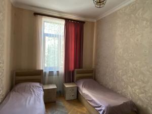 two beds in a room with a window at HovSer in Yerevan