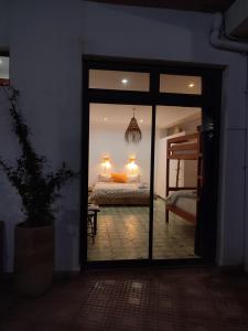 イムスワンにあるImsouane Surf Paradiseのベッドルームに通じるガラスドアとベッド1台が備わる客室です。