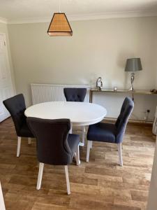una mesa blanca y sillas en una habitación en 37 The Street, Weeley, Clacton on Sea, Essex CO16 9JD, en Weeley