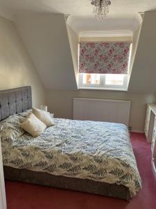 een slaapkamer met een bed met een raam en een bed sidx sidx sidx bij 37 The Street, Weeley, Clacton on Sea, Essex CO16 9JD in Weeley