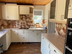 a kitchen with white cabinets and a counter top at 37 The Street, Weeley, Clacton on Sea, Essex CO16 9JD in Weeley