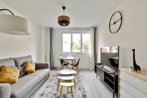 a living room with a couch and a table at Chic studio near Paris - La Defense in Bezons