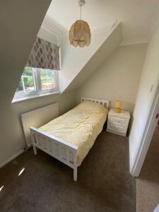 een kleine slaapkamer met een bed en een raam bij 37 The Street, Weeley, Clacton on Sea, Essex CO16 9JD in Weeley
