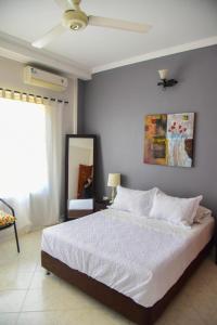 1 dormitorio con 1 cama y ventilador de techo en VG Villa Gloria, en Santa Marta