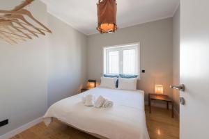 1 dormitorio con 1 cama blanca y 2 toallas en Ceuta 33 Apartment, en Oporto