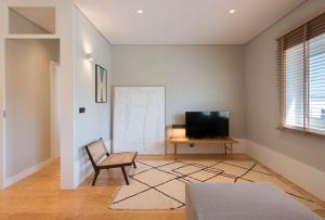 sala de estar con silla y TV en Ceuta 33 Apartment, en Oporto