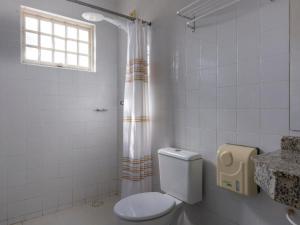 Un baño blanco con inodoro y ducha. en Hotel Expoflora, en Cosmópolis