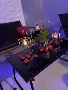 - une table noire avec des bougies et des fleurs dans l'établissement Medusa spa 34, à Montpellier
