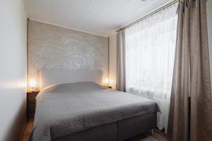 a bedroom with a bed and a large window at Kuuse 4 Apartment with 2 bedrooms in Haapsalu