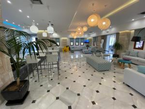 a lobby with a waiting area with white furniture at Kyknos Beach Hotel & Bungalows in Malia