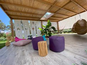 a patio with purple chairs and a wooden ceiling at Kyknos Beach Hotel & Bungalows in Malia