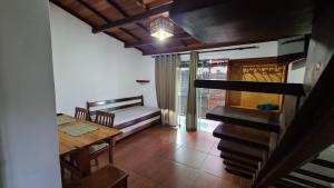 a dining room with a table and a bench and a table and a dining table at Linda Surf House Apartamentos in Itacaré
