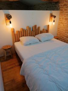 um quarto com uma cama grande e uma cabeceira em madeira em Gite Pays de Joie 