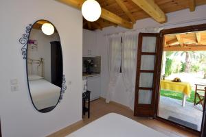 a kitchen and a living room with a mirror at Haus Katerina in Vourvourou