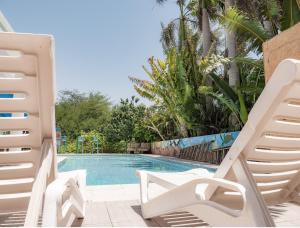een zwembad met 2 ligstoelen en een zwembad bij Dive Time Villa in Eilat