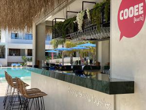 a restaurant with a bar with chairs and a pool at Kyknos Beach Hotel & Bungalows in Malia