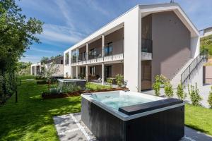 una casa con bañera de hidromasaje en el patio en SHILOH Private Luxury Apartments, en Costermano