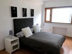 a bedroom with a black bed with a window at El Coqueto de Segovia in El Espinar
