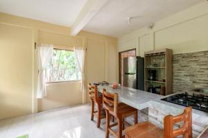 a kitchen with a counter and a table with chairs at Casa Chilamates 2.0 in Tortuguero