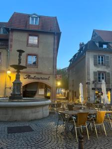a courtyard with tables and chairs and a fountain at Cocon Accès facile Parking Gratuit in Belfort
