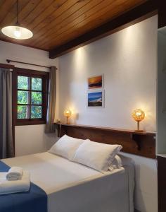 Un dormitorio con una cama grande y una ventana en Pousada Morada Flor da Terra, en Guarda do Embaú