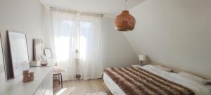 a white bedroom with a bed and a window at Cocoon Bed and Breakfast in Fegersheim