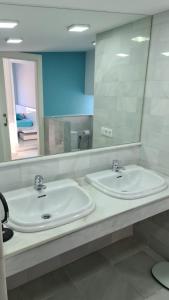 uma casa de banho com 2 lavatórios e um espelho grande em TRIPLEX DE LUJO EN MOJACAR em Mojácar