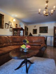 een woonkamer met een bruine leren bank en een tafel bij Apartmán u Anjela in Banská Štiavnica