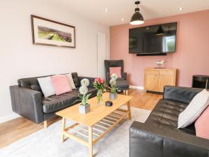 a living room with a couch and a table at The Coach House, Bank Top Farm in Ashbourne