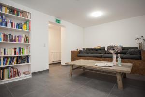 een woonkamer met een salontafel en boekenplanken bij NaturLiebe in Winterberg
