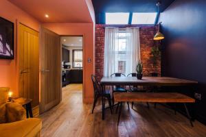 a dining room with a table and a brick wall at Four Bedroom Urban Home hosted by MCR Dens in Manchester