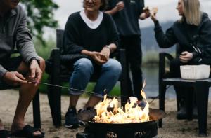 Eine Gruppe von Menschen, die um ein Feuer herum sitzen in der Unterkunft Summerland Waterfront Resort & Spa in Summerland