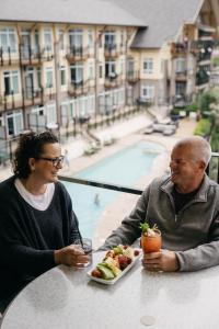 mężczyzna i kobieta siedzący przy stole z talerzem jedzenia w obiekcie Summerland Waterfront Resort & Spa w mieście Summerland