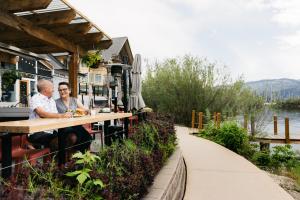 a man and woman sitting at a table at a restaurant at Summerland Waterfront Resort & Spa in Summerland