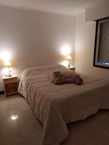 1 dormitorio con 1 cama grande y 2 lámparas en La Paz en Lobos