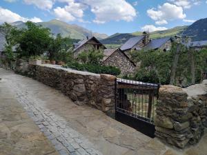 una pared de piedra con una puerta en un pueblo en Ca de Callet - planta baixa, en Taüll