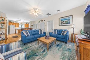 una sala de estar con sofás azules y una mesa. en The Rookery Unit 3601 en Gulf Shores