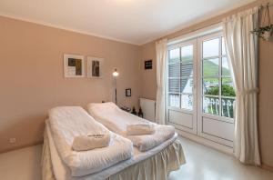 a bedroom with a bed and a large window at visitHOMES Faroe Islands in Leirvík