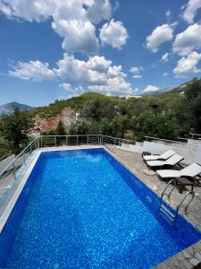 a swimming pool with two lounge chairs next to it at Apartment Maestral with sea view in Pržno