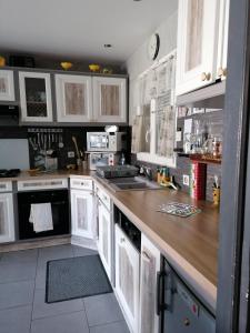 a kitchen with white cabinets and a wooden counter top at Christophe in Crest