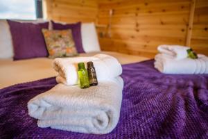 a pile of towels on a purple bed at Kings Caves Glamping in Torbeg
